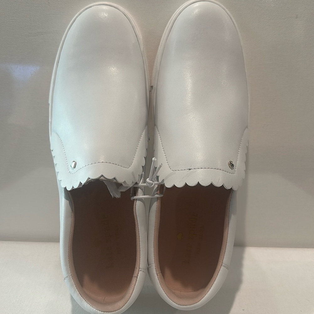 Kate Spade New York White Slip on Sneakers with Silverton Heart on the top.